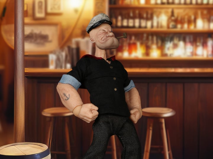 The One:12 Collective Popeye figure includes two masterfully crafted head portraits: a stern stare and a salty glare. Authentically presented in his classic sailor clothing and a removable pea coat, Popeye comes complete with a wide range of accessories including: a functional drawstring duffle bag, a collapsible spy glass, a compass with hinged lid, two spinach cans, three different hats, and two styles of corncob pipes.
