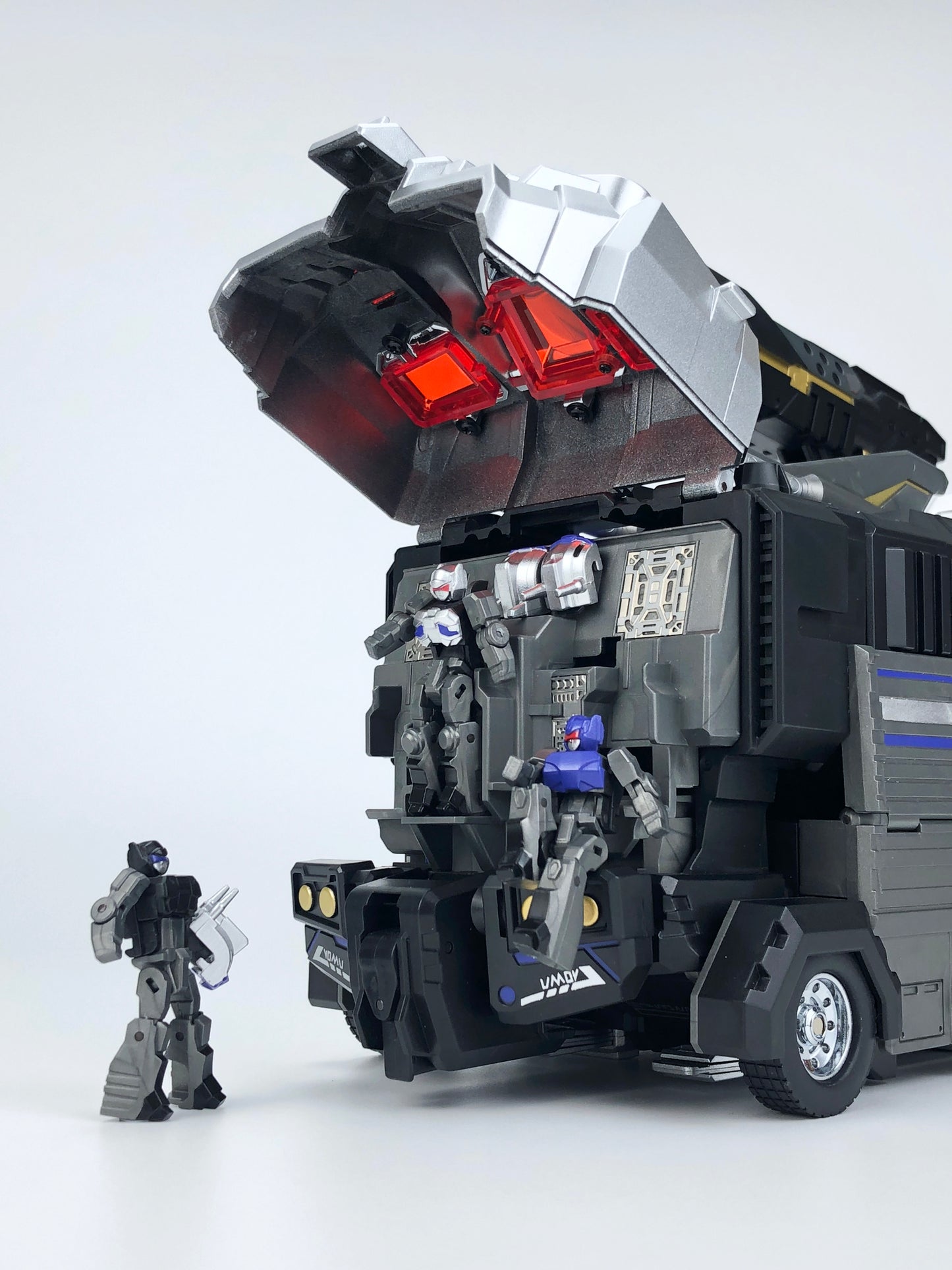 Fans Hobby presents the MB-011A Black God Armor as part of the Master Builder series!  This transforming figure converts from robot mode to trailer mode and back again. Black God Armor can be combined with the Master Builder MB-06A Black Power Baser figure (sold separately).